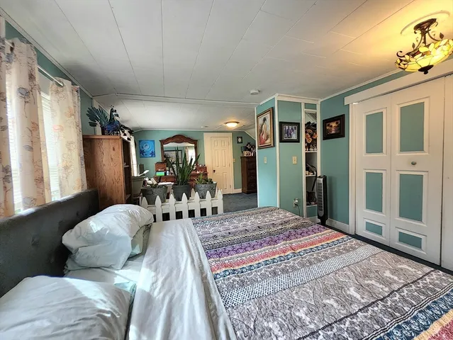 a bed sitting in a bedroom next to a window