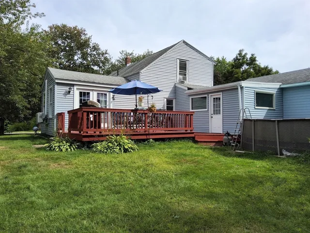 a view of a house with a yard and deck