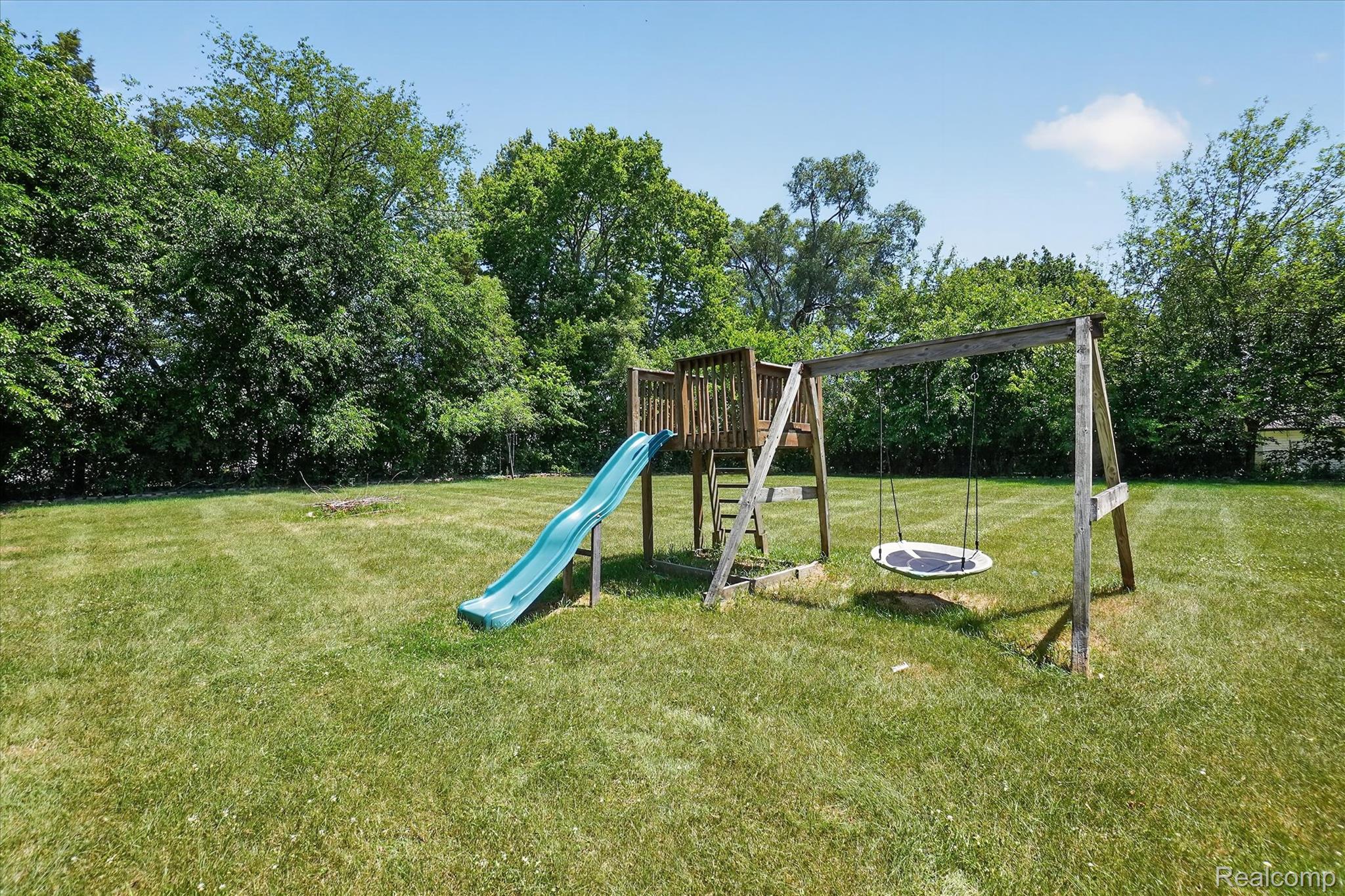 508 Deland Road Flushing, MI 48433 - Photo 38 of 38 Expansive grassy lawn featuring a wood play structure with a slide and swing