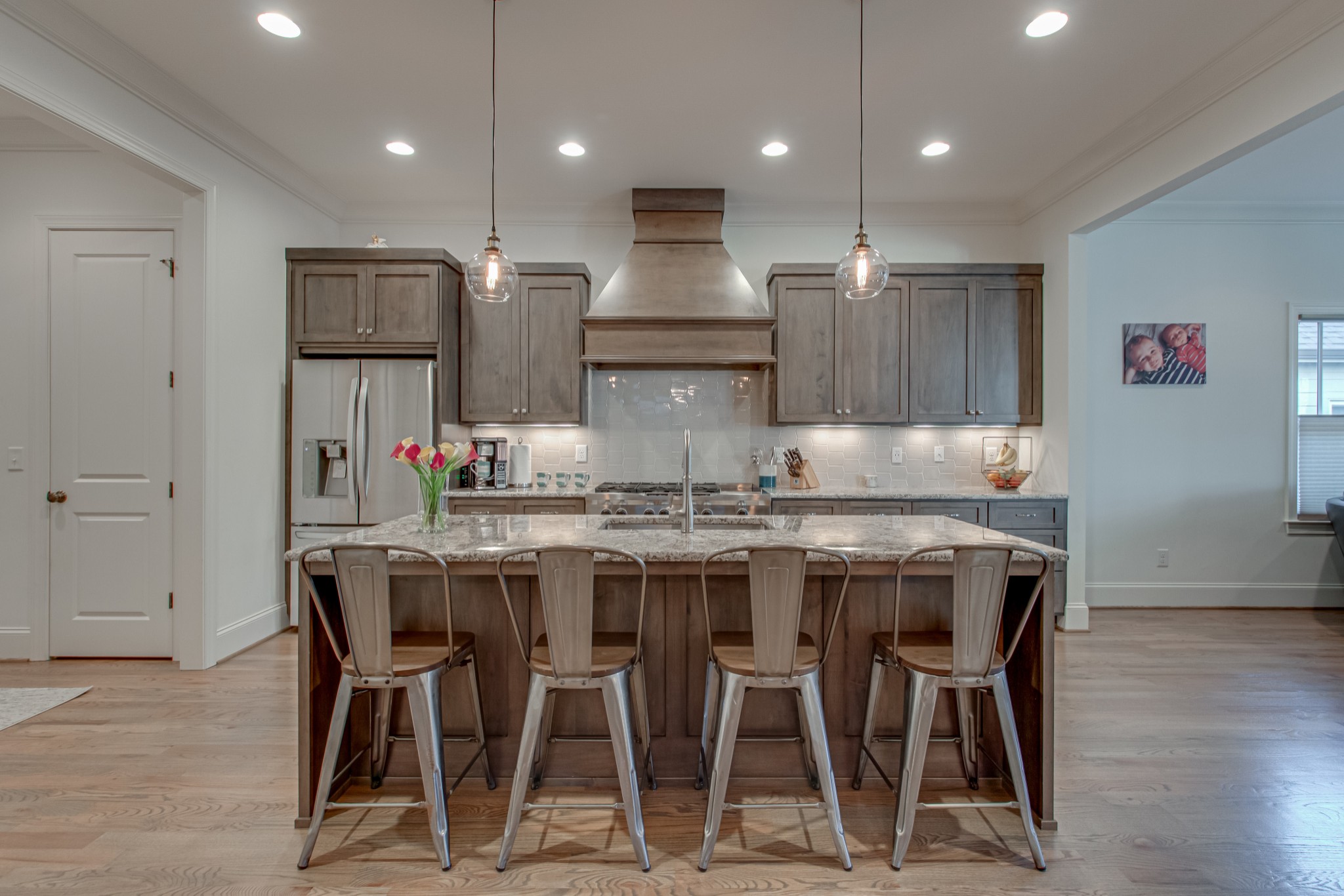 a kitchen with kitchen island granite countertop wooden floor cabinets and stainless steel appliances