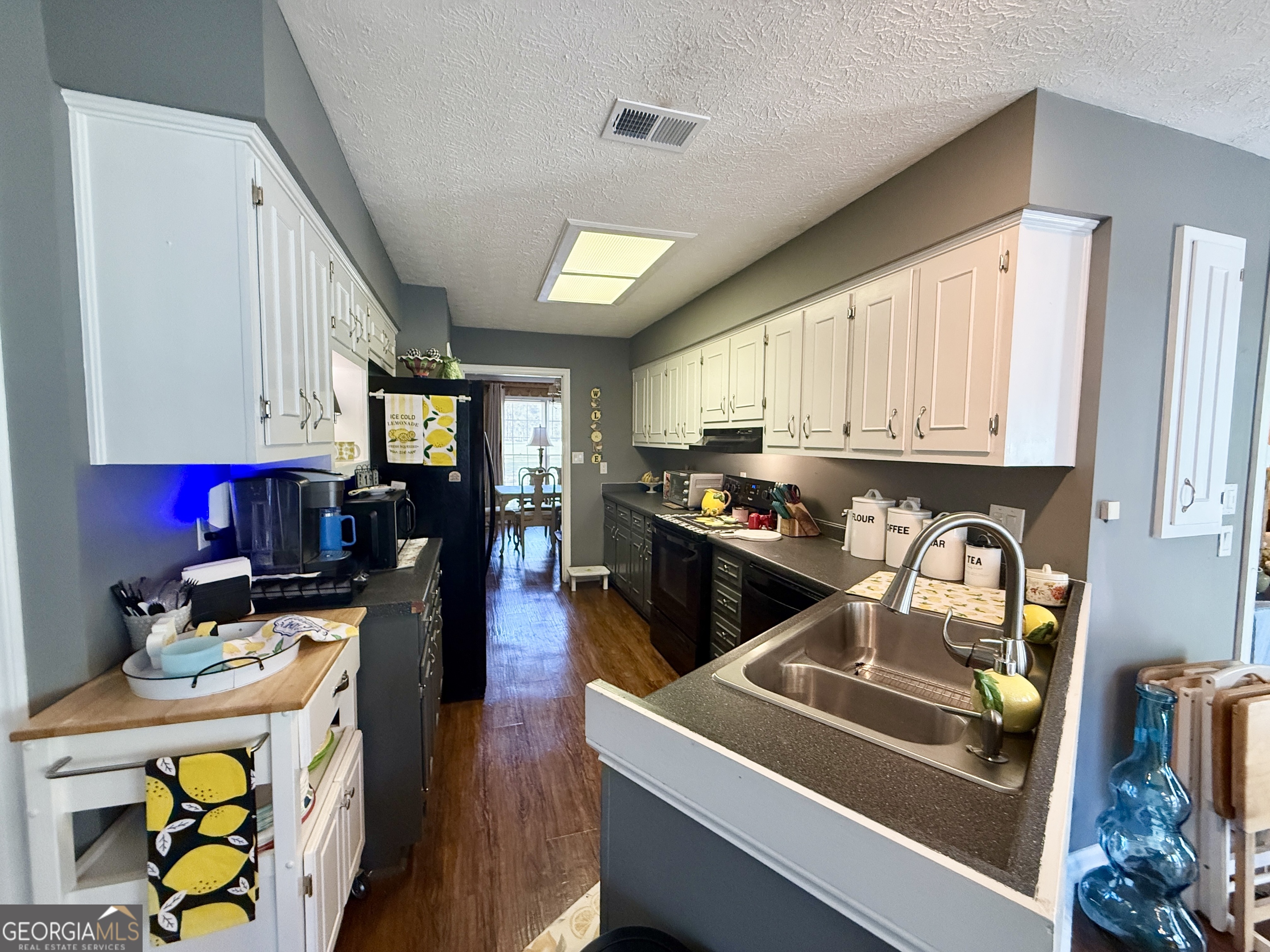 104 Monte Place Cordele, GA 31015 - Photo 13 of 52 a kitchen with a stove a refrigerator sink dishwasher and cabinets with wooden floor