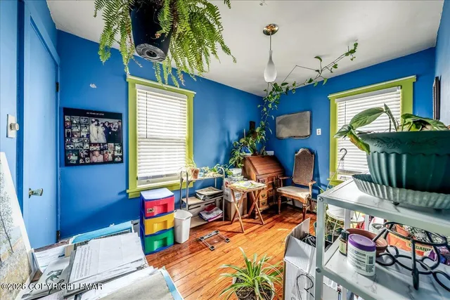a view of a hallway with wooden floor and cabinets