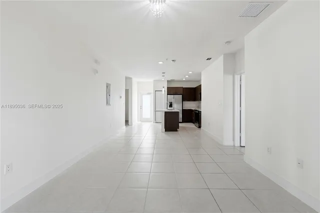 a view of kitchen with refrigerator and window