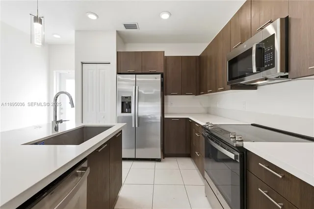 a kitchen with stainless steel appliances a sink microwave and stove