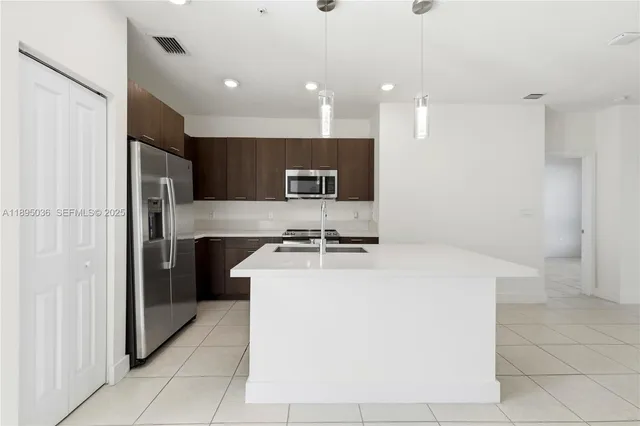 a kitchen with a sink a refrigerator and a stove