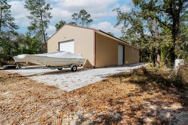 a view of a house with a yard and large tree