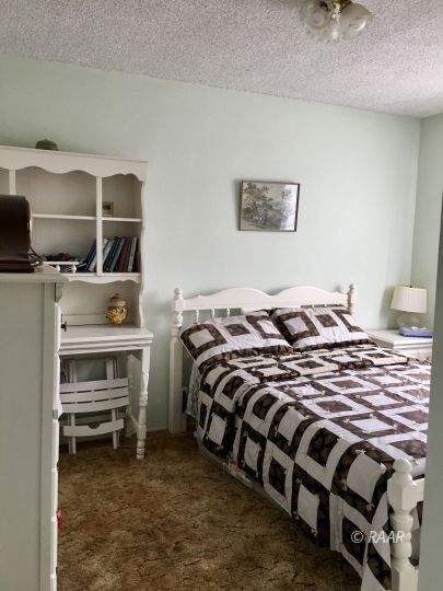 1321 South McCall Street Ridgecrest, CA 93555 - Photo 12 of 23 a bedroom with a bed and a chandelier