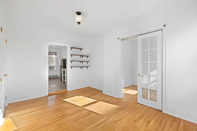 a view of empty room with wooden floor