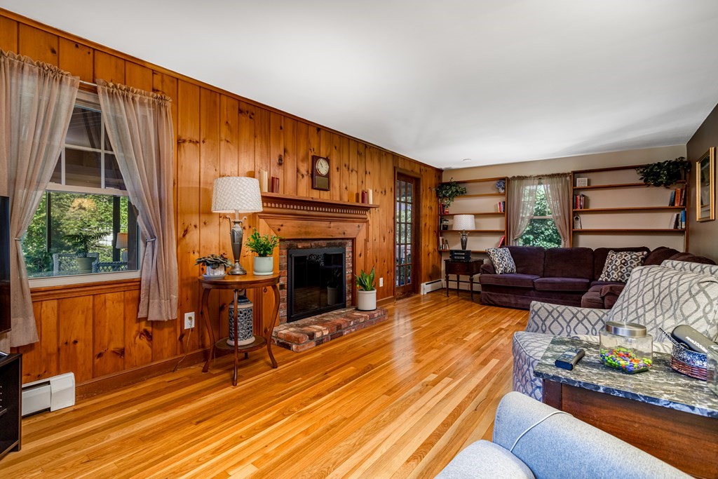 2 Victor Drive Ayer, MA 01432 - Photo 16 of 42 a living room with furniture a fireplace and a floor to ceiling window