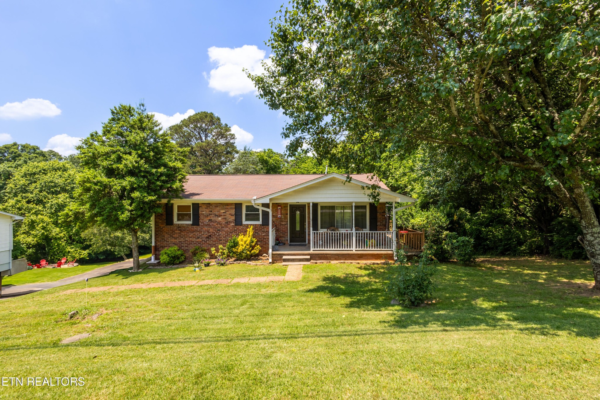 a front view of a house with yard and green space