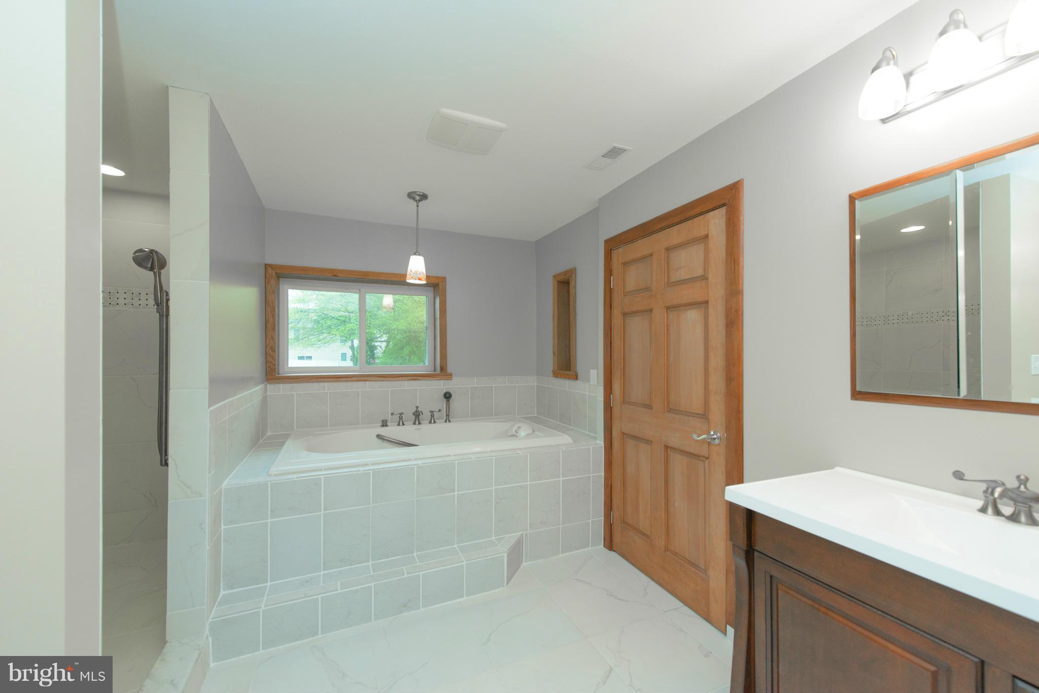 8213 WB&A Road Severn, MD 21144 - Photo 26 of 30 a bathroom with a tub sink and mirror