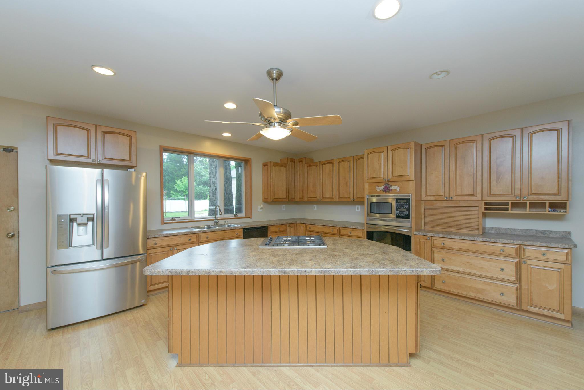 8213 WB&A Road Severn, MD 21144 - Photo 6 of 30 a kitchen with stainless steel appliances granite countertop a refrigerator a stove and a sink with wooden floor