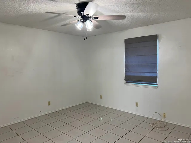 an empty room with closet and a chandelier fan