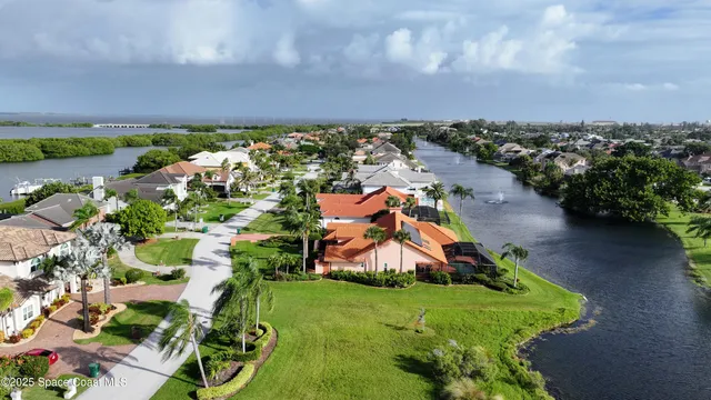 a view of a big house with a big yard and potted plants