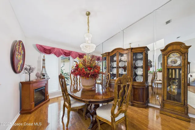 a view of a dining room with furniture a chandelier and a large window