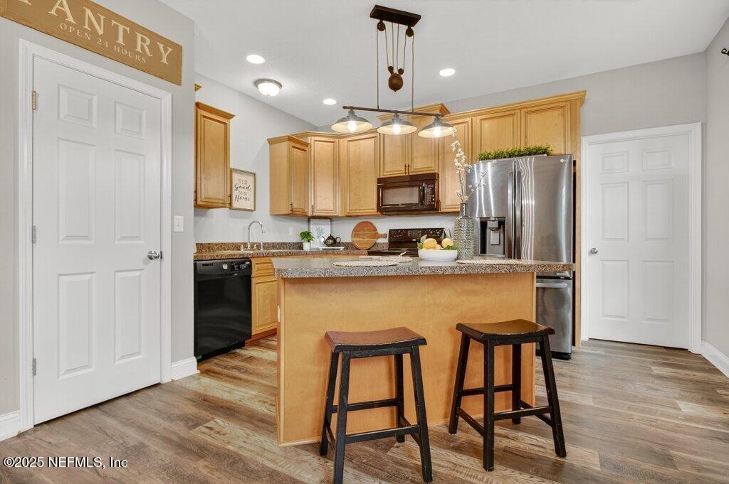 204 Comer Road Palatka, FL 32177 - Photo 15 of 61 a kitchen with stainless steel appliances granite countertop a refrigerator a stove a sink dishwasher and microwave with wooden floor