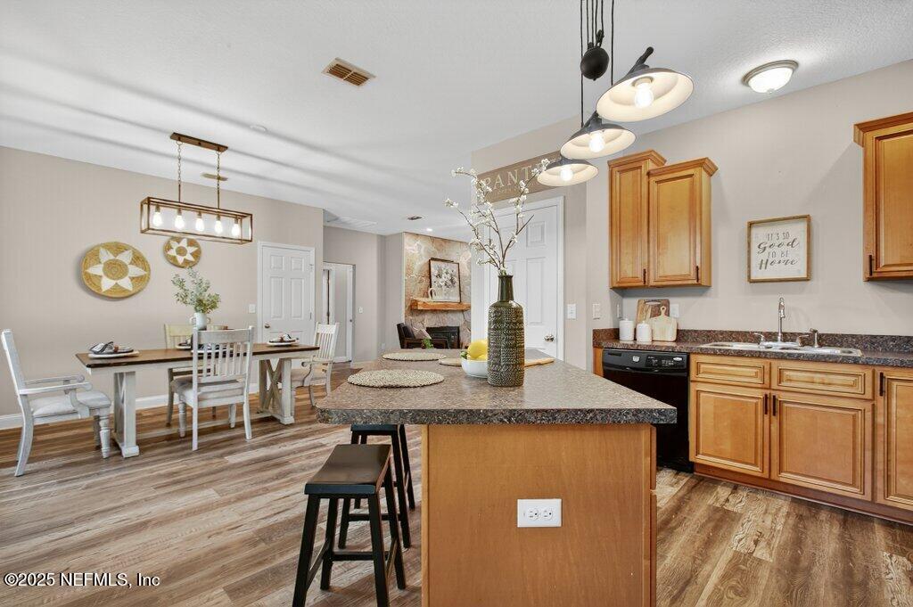 204 Comer Road Palatka, FL 32177 - Photo 20 of 61 a kitchen with stainless steel appliances granite countertop a stove a refrigerator a sink a dining table and chairs with wooden floor