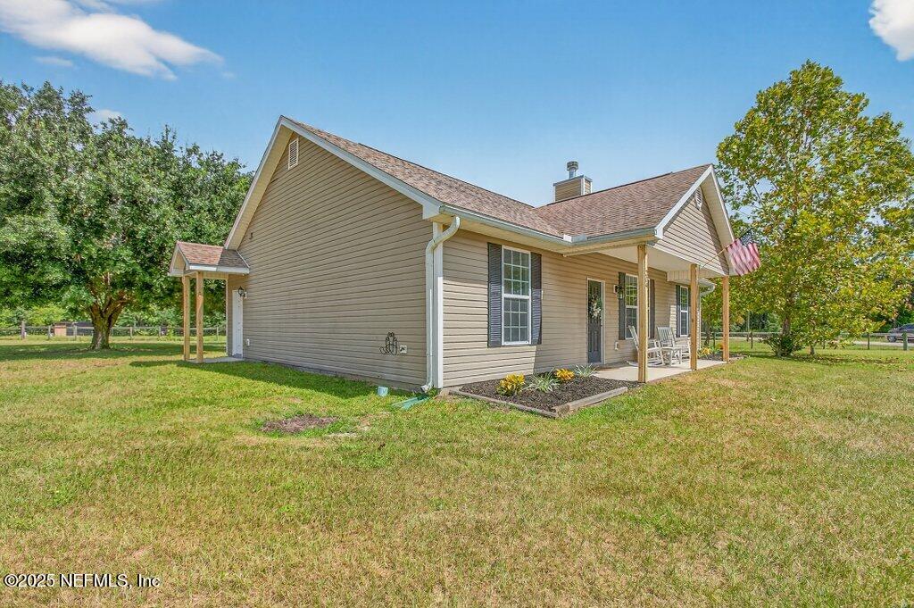 204 Comer Road Palatka, FL 32177 - Photo 42 of 61 a front view of house with yard outdoor seating and trees in the background