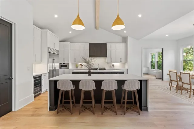 a dining hall with stainless steel appliances a dining table and chairs