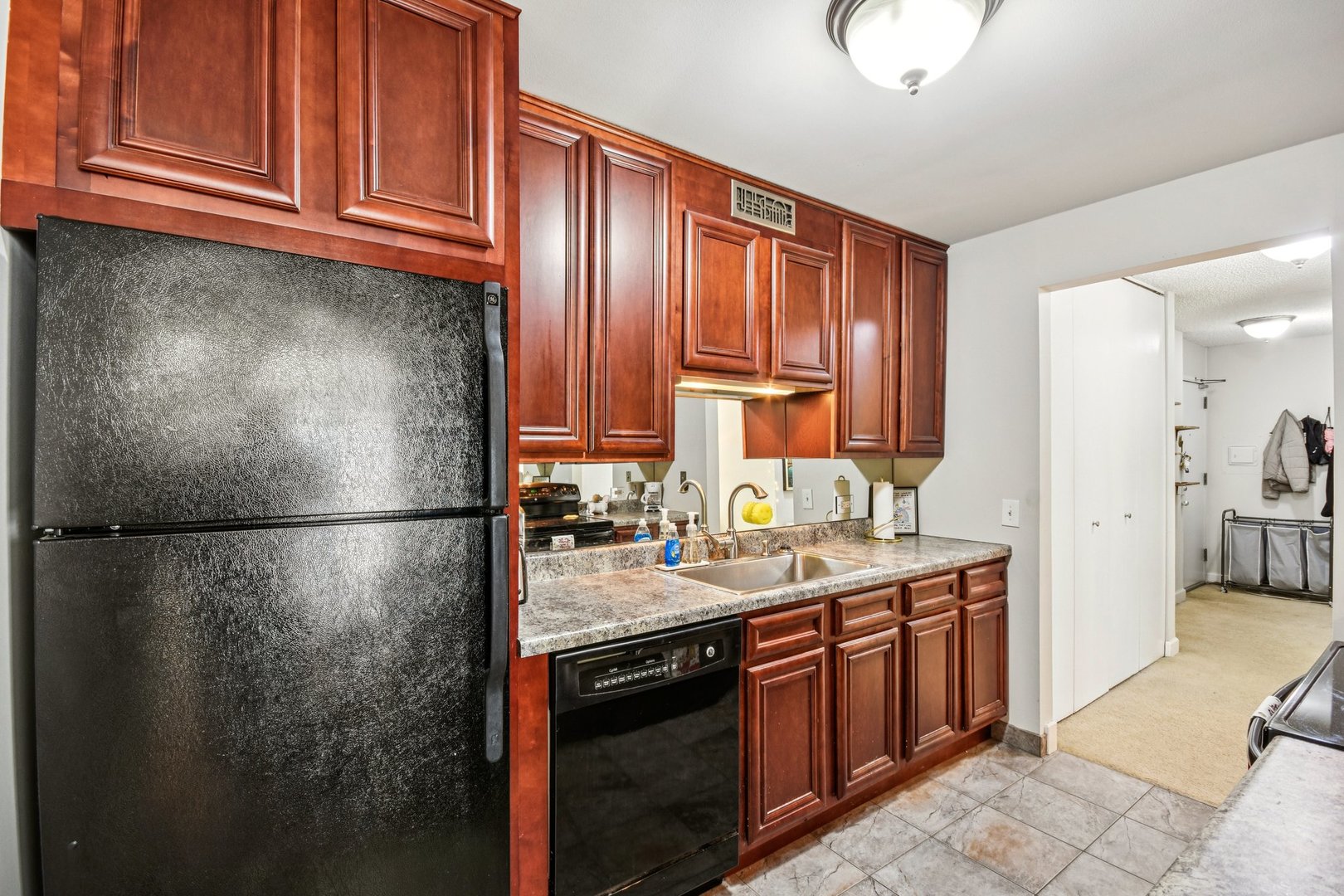 200 North Dearborn Street, Unit 1303 Chicago, IL 60601 - Photo 11 of 32 a kitchen with stainless steel appliances granite countertop a refrigerator a sink dishwasher a stove with wooden cabinets