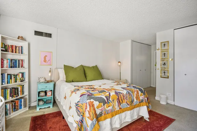 a bed sitting in a bedroom next to a book shelf