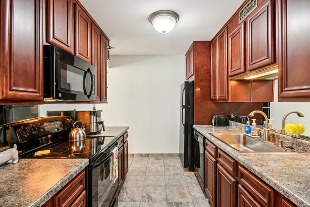 a kitchen with stainless steel appliances granite countertop a sink stove and cabinets