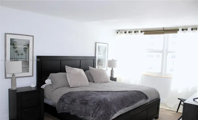 a bedroom with a bed window and a table chair