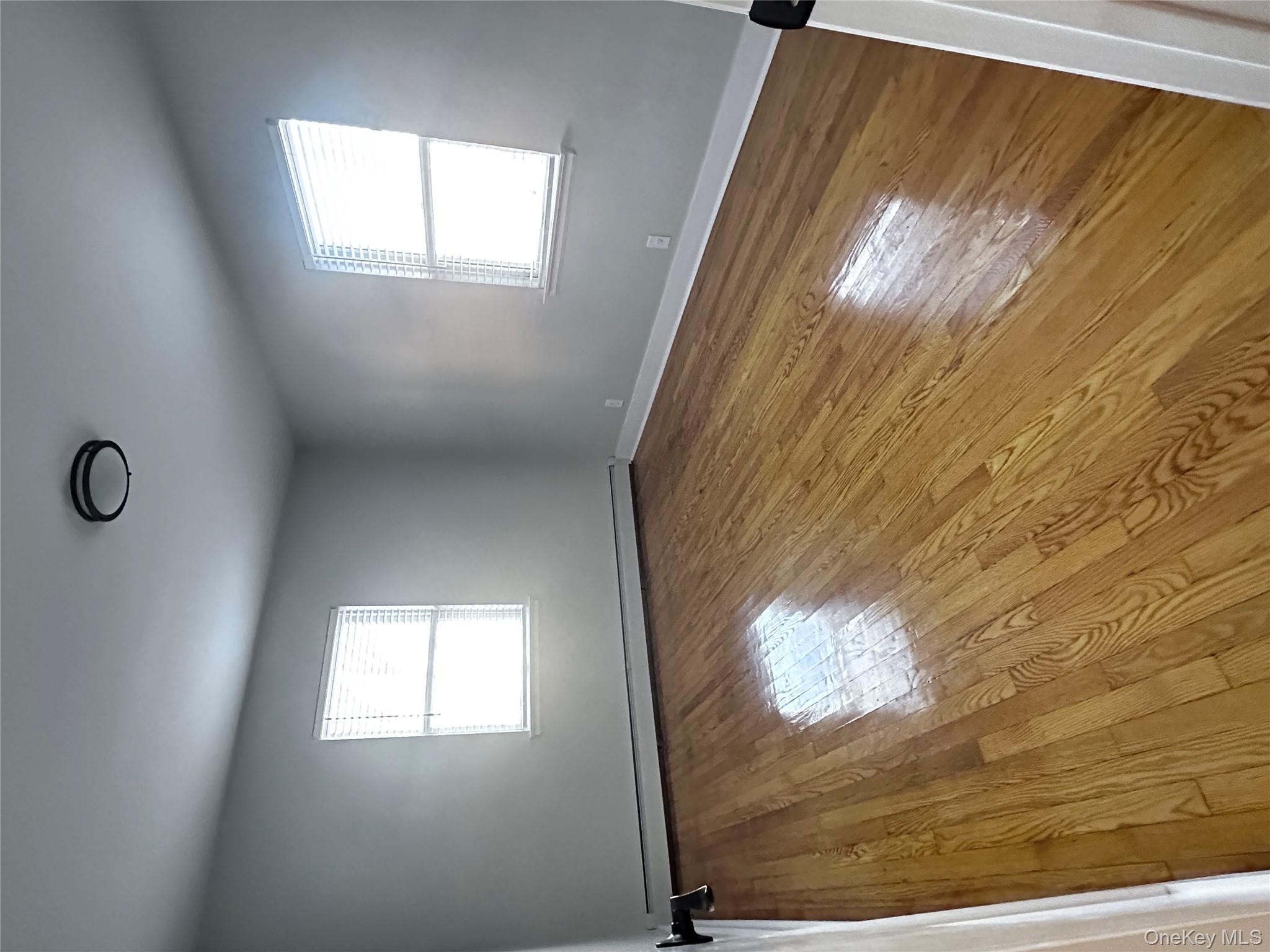 1233 Lydig Avenue, Unit 1 Bronx, NY 10461 - Photo 12 of 20 an empty room with wooden floor and windows