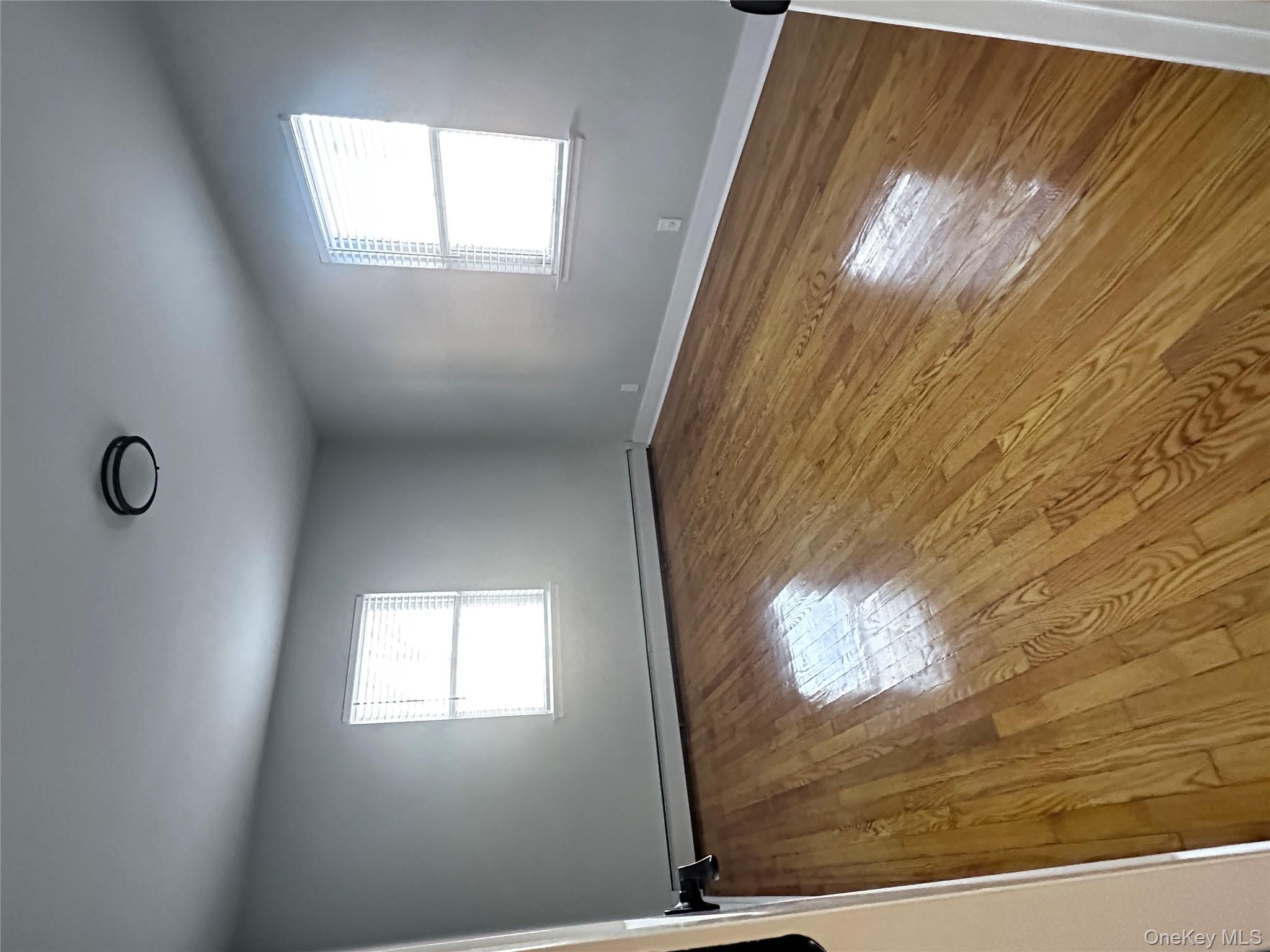 1233 Lydig Avenue, Unit 1 Bronx, NY 10461 - Photo 13 of 20 an empty room with wooden floor and windows