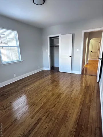an empty room with wooden floor and window