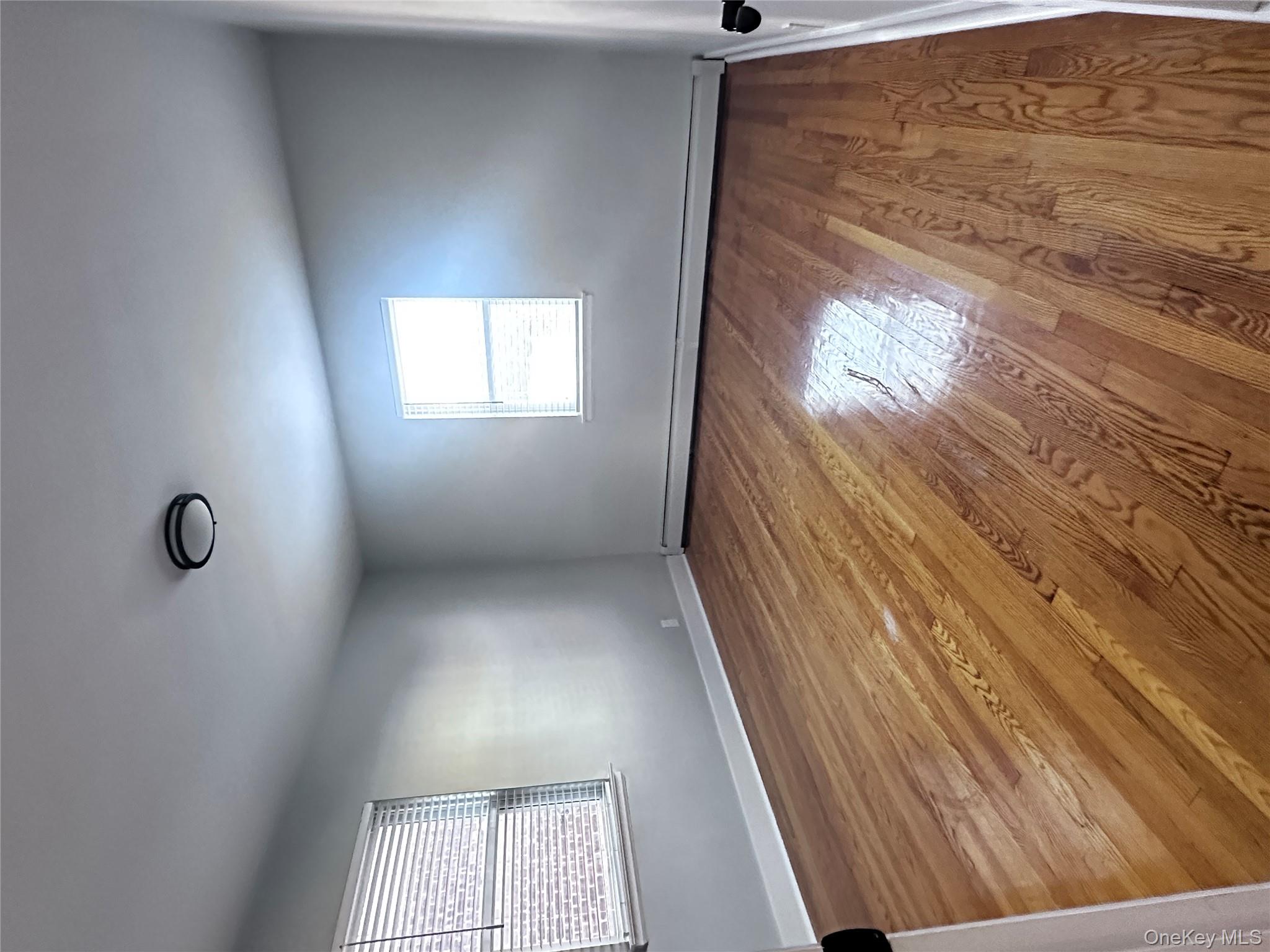 1233 Lydig Avenue, Unit 1 Bronx, NY 10461 - Photo 16 of 20 an empty room with wooden floor and windows