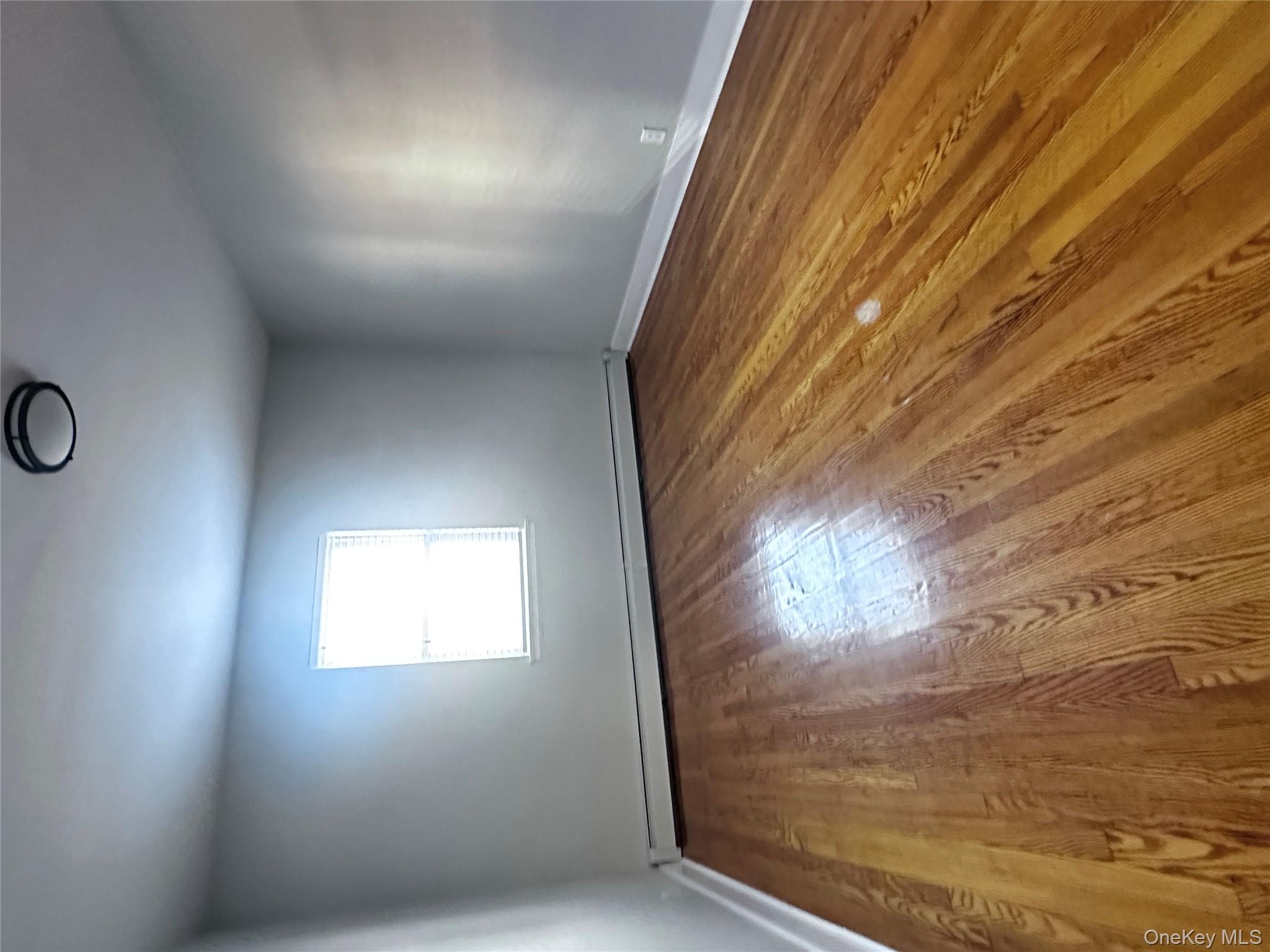 1233 Lydig Avenue, Unit 1 Bronx, NY 10461 - Photo 18 of 20 an empty room with wooden floor and windows