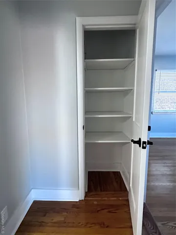a view of walk in closet with wooden floor and a cabinet