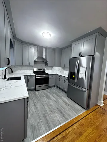 a kitchen with granite countertop a refrigerator stove and sink