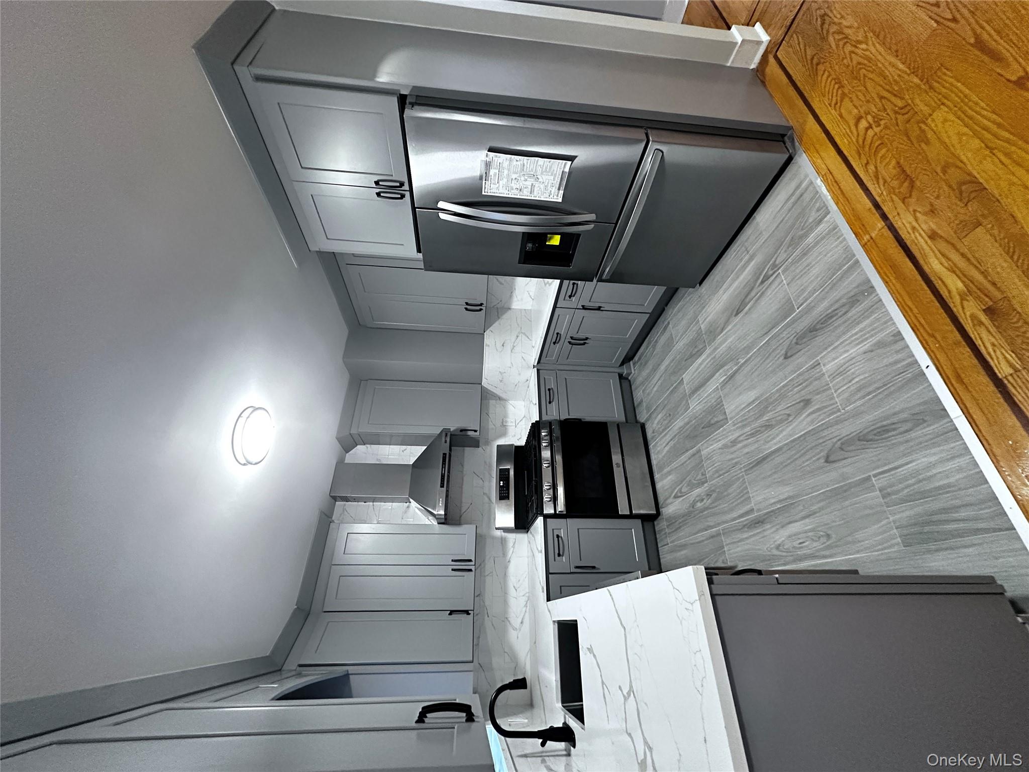 1233 Lydig Avenue, Unit 1 Bronx, NY 10461 - Photo 4 of 20 a kitchen with granite countertop a refrigerator stove and sink