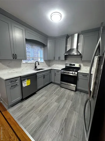 a kitchen with stainless steel appliances granite countertop a stove a sink and a refrigerator