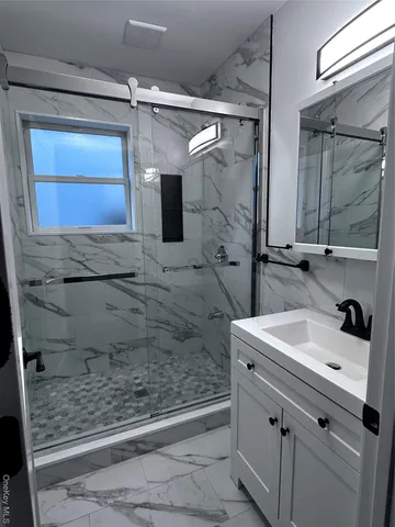 a bathroom with a sink a toilet and shower