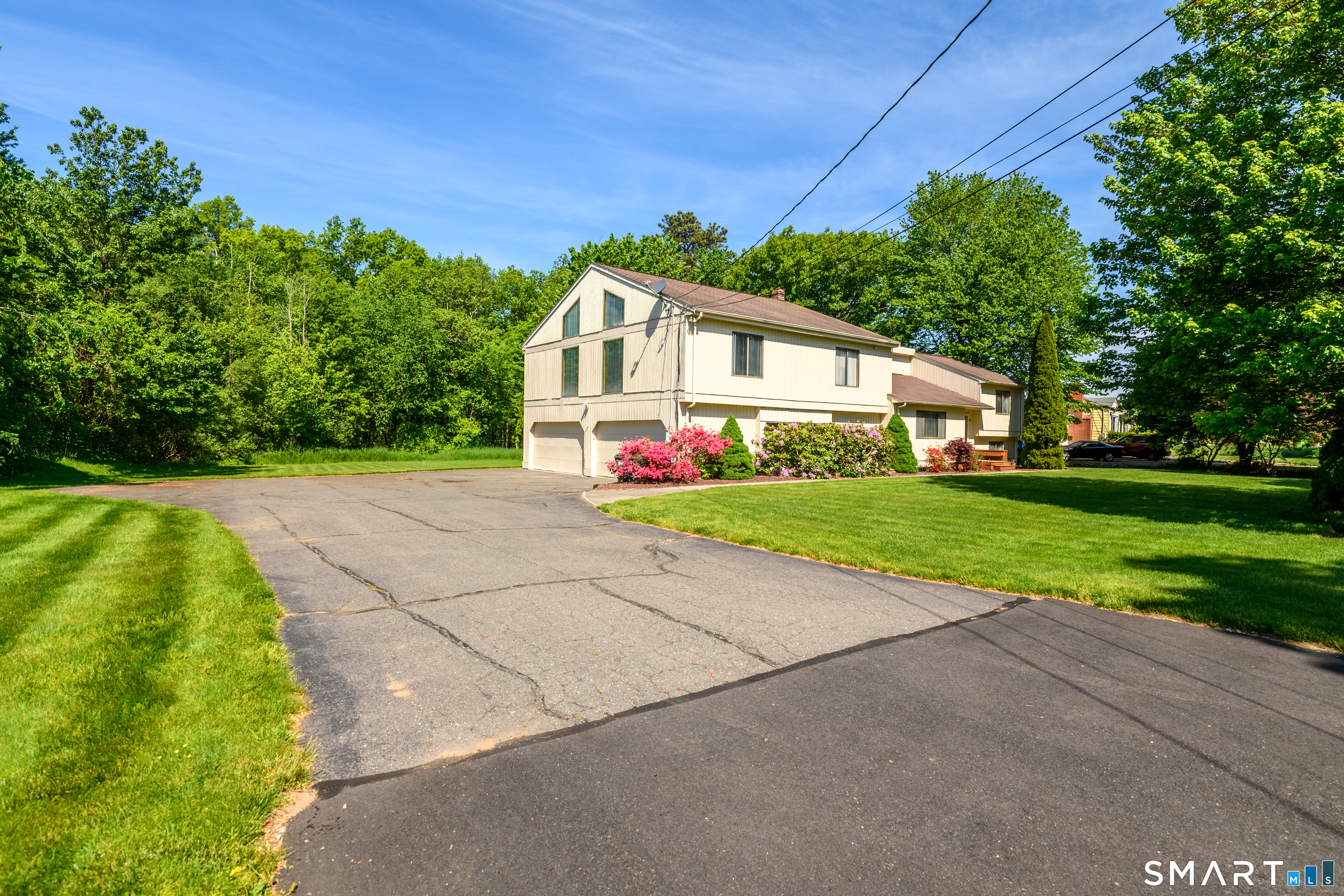 90 Bell Street Manchester, CT 06040 - Photo 2 of 40 a white house with a small yard plants and large trees