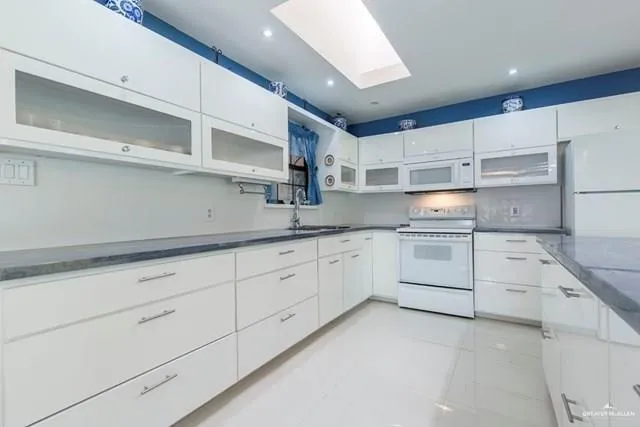 a kitchen with white cabinets stainless steel appliances and sink