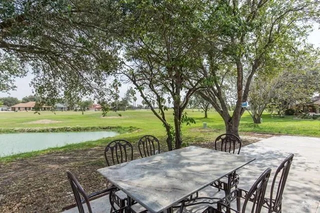 a view of a patio with a table chairs and a backyard