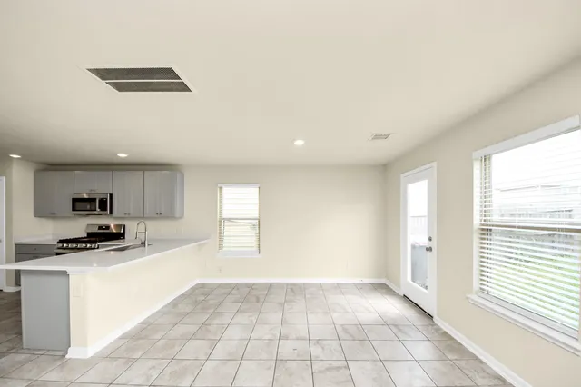 a kitchen with granite countertop a stove a sink and a refrigerator