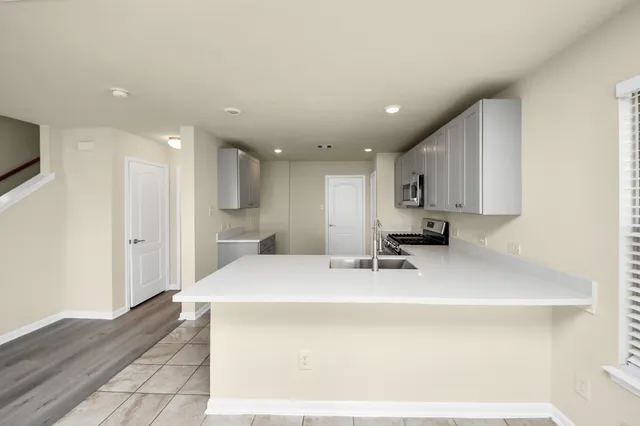 a kitchen with kitchen island a sink stainless steel appliances and cabinets