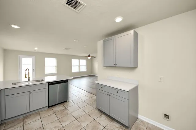a kitchen with white cabinets and sink
