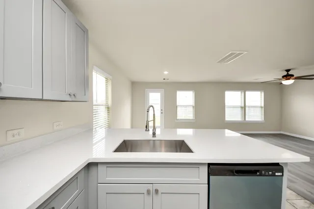 a kitchen with a sink a window and cabinets