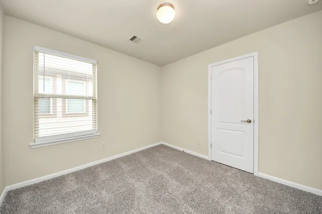 an empty room with windows and closet