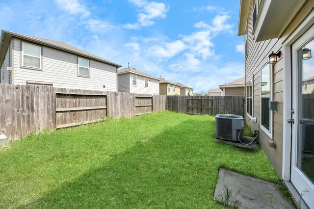 a view of a backyard with potted plants and a large tree