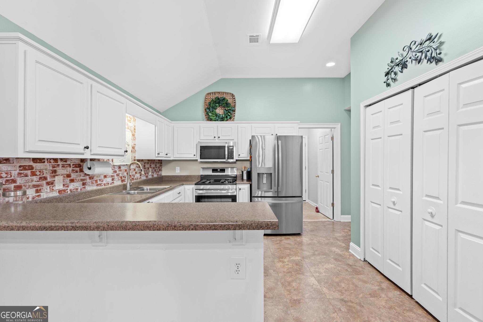 291 Lora Smith Road Newnan, GA 30265 - Photo 14 of 37 a kitchen with stainless steel appliances granite countertop a refrigerator a stove and a sink