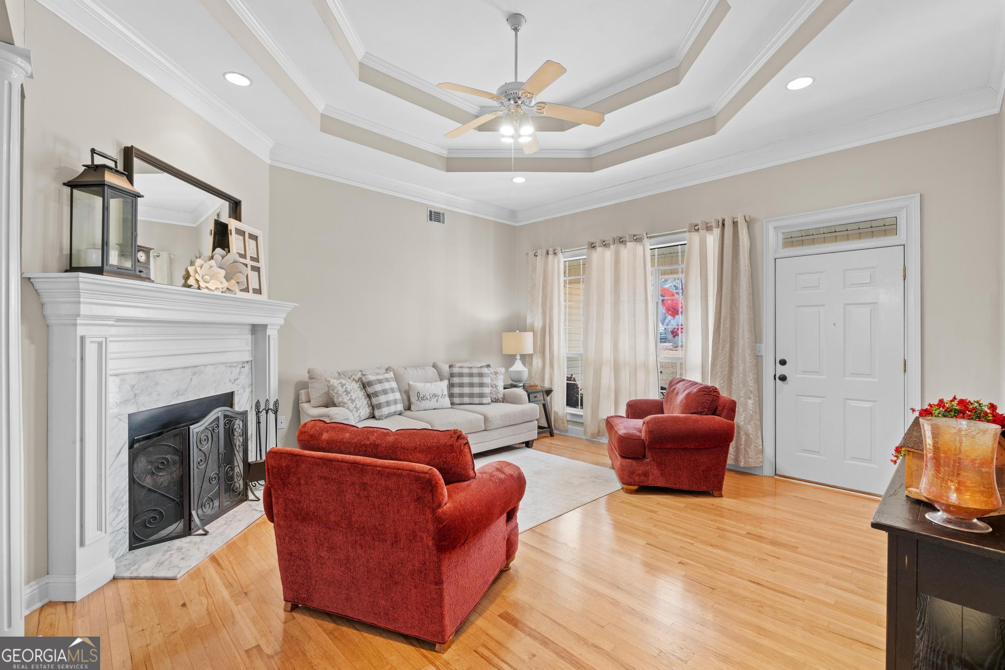 291 Lora Smith Road Newnan, GA 30265 - Photo 6 of 37 a living room with furniture a fireplace and a chandelier