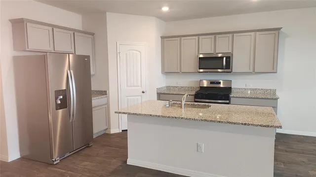 a kitchen with stainless steel appliances granite countertop a refrigerator stove microwave and sink