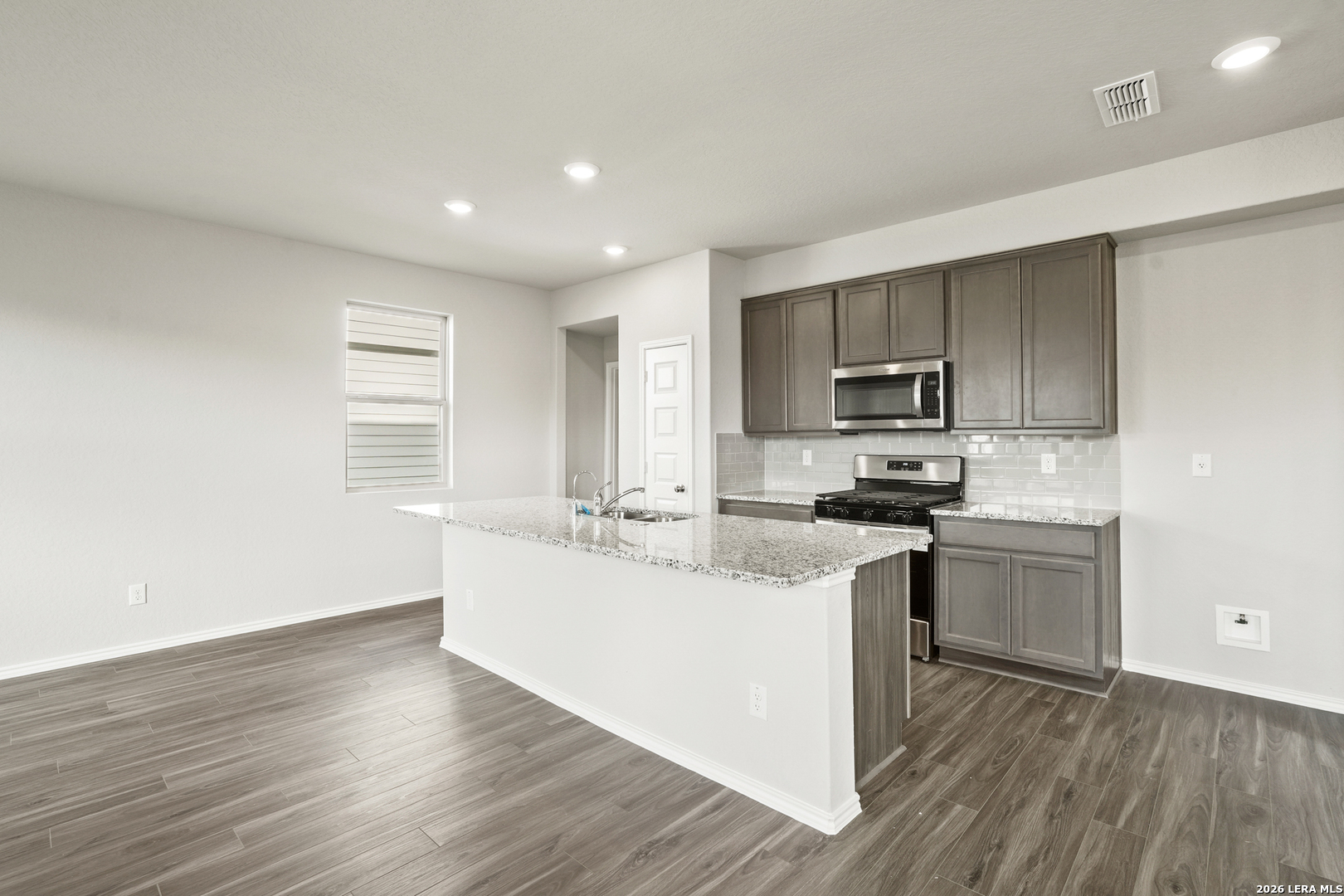 4951 Blue Ranch San Antonio, TX 78222 - Photo 2 of 36 a kitchen with a sink wooden floor and stainless steel appliances
